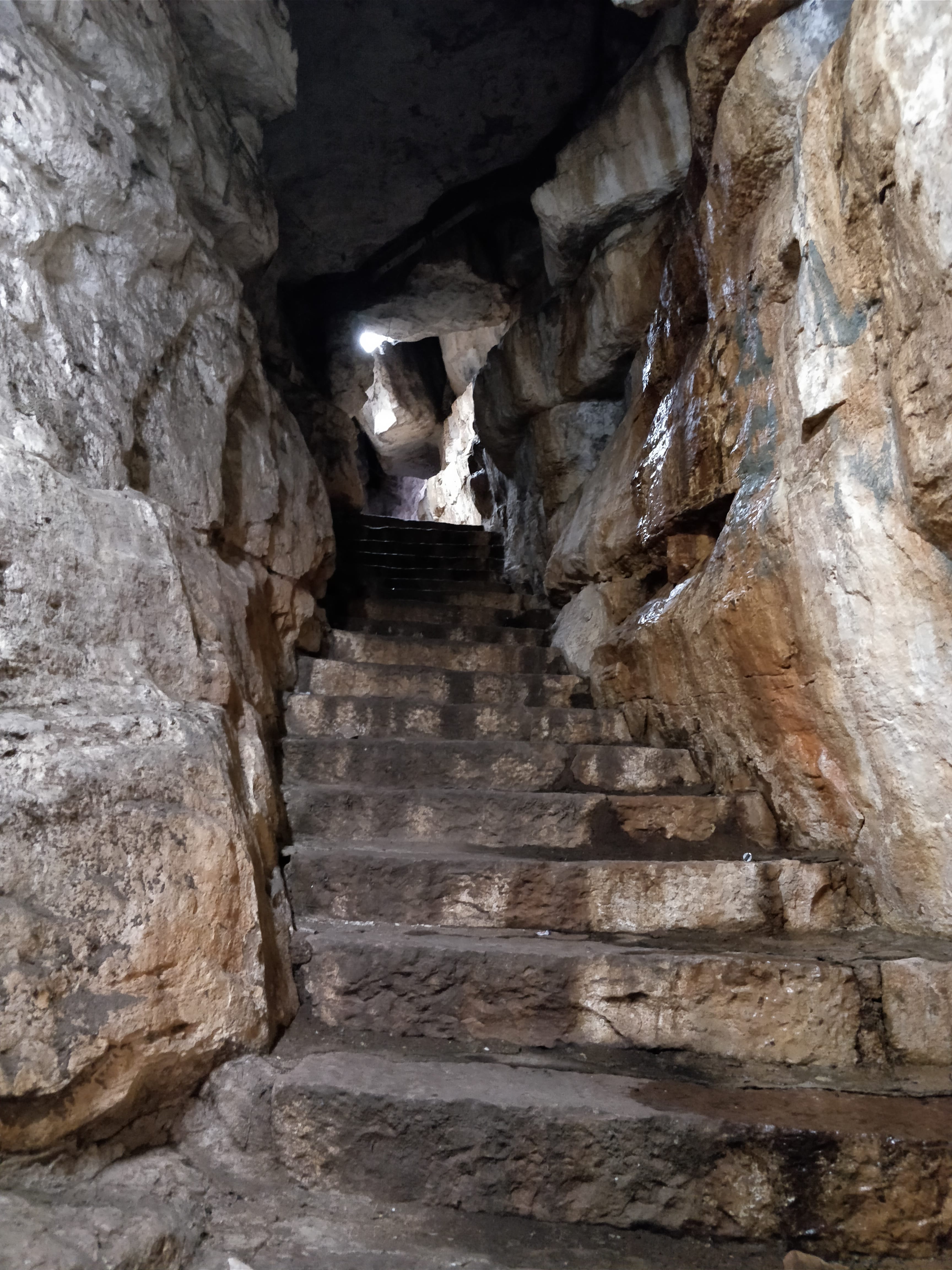 Stone steps chiseled into the rocks. Cave like passage to go to the bottom of Gokak falls